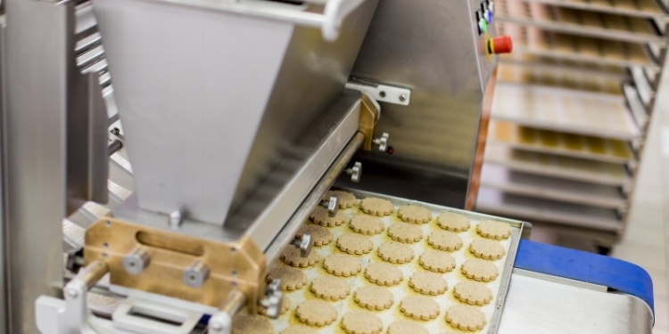 Cookies exiting industrial oven on food grade stainless steel baking tray