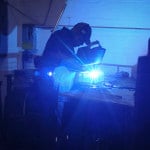 A worker welding a custom basket.