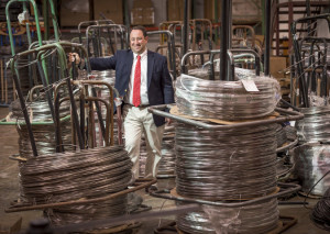 Marlin President Drew Greenblatt next to a stack of steel wire coils