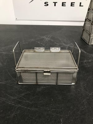 This stainless steel mesh basket has large handles for easy carrying and a tight lid to keep parts in the basket.