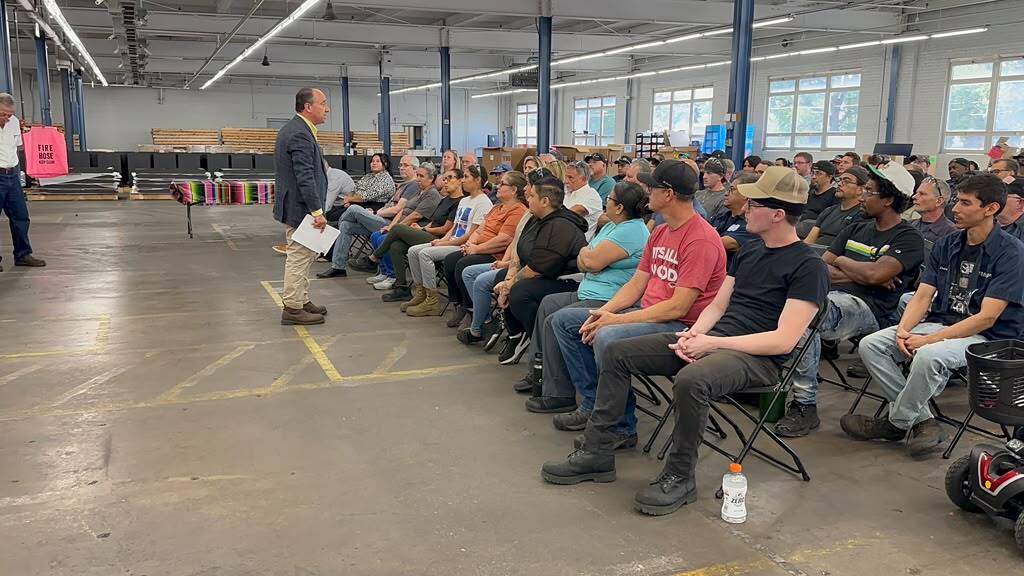 Drew GreenBlatt communicates with seated employees.