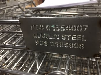 A laser-cut steel sheet tag on a custom wire basket.