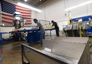 Marlin factory workers setting up a work piece for the IDEAL resistance welding machine.